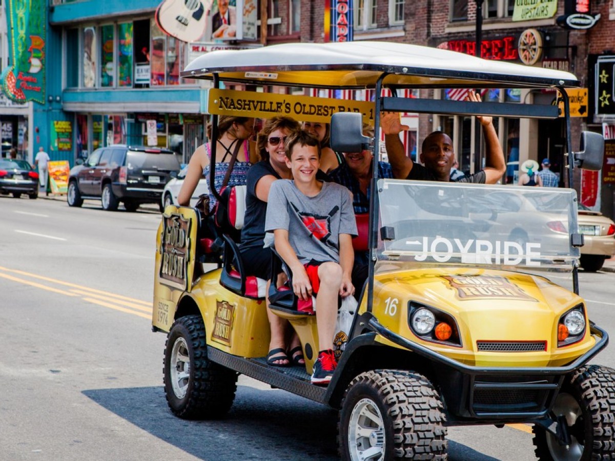 a person riding on the back of a truck on a city street