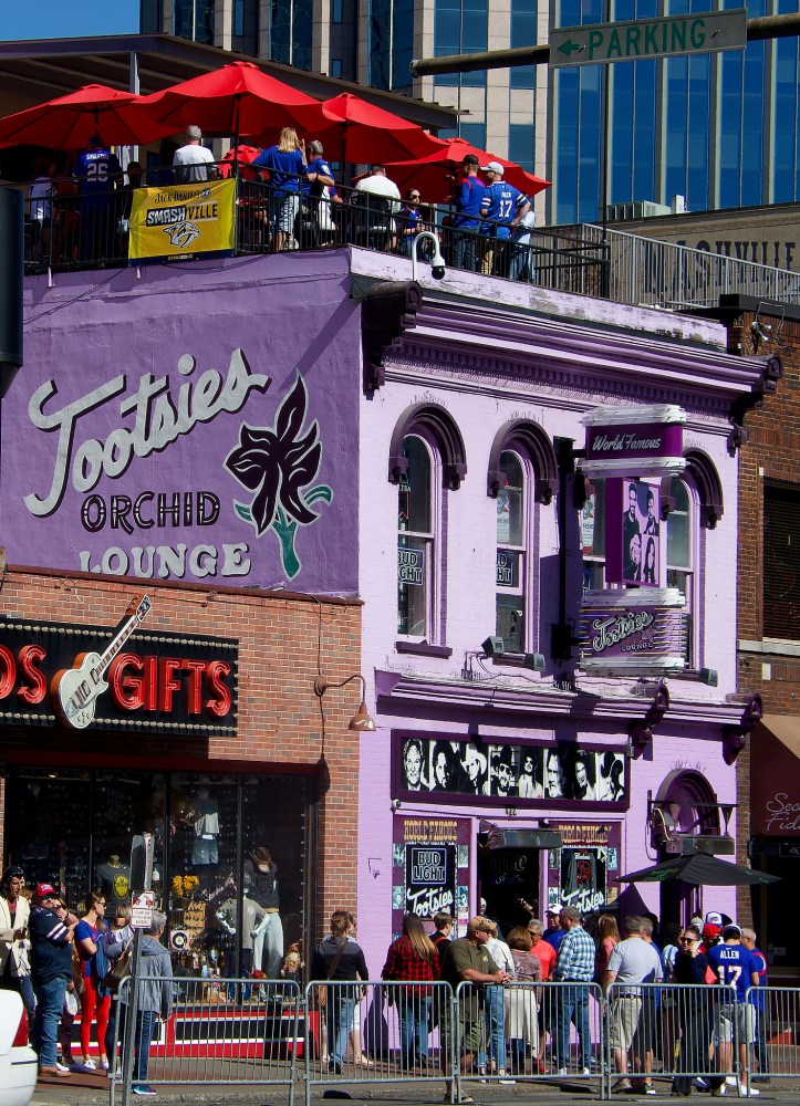 a crowd of people walking in front of a building
